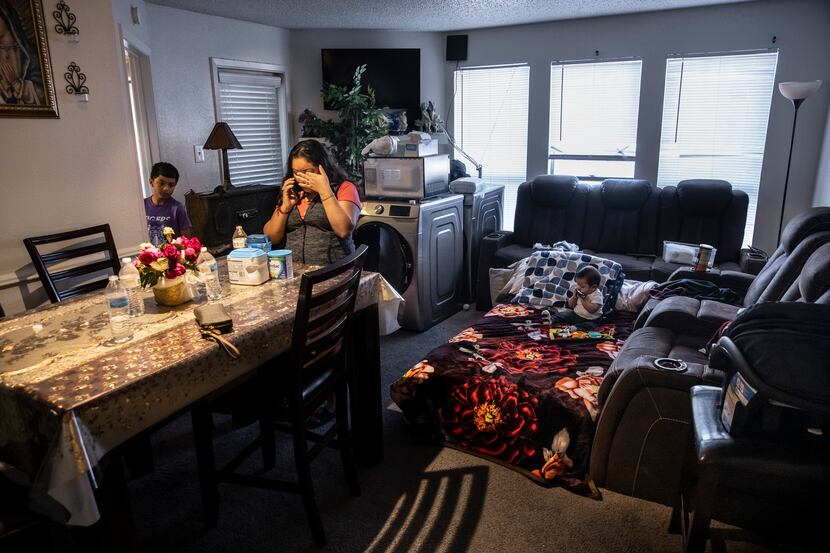 Maria Magarin takes a phone call while standing in the living room of her apartment at The...