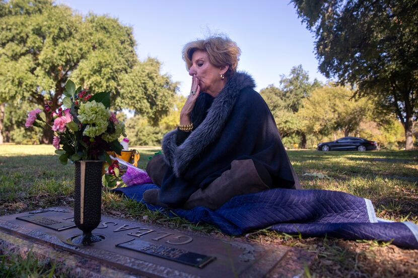 Shannon Dion kisses her parents' graves at Restland Memorial Park in Dallas on Oct. 31,...