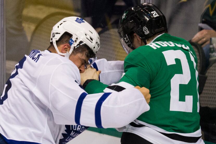 Dallas Stars left wing Antoine Roussel (21) takes a punch from Toronto Maple Leafs...