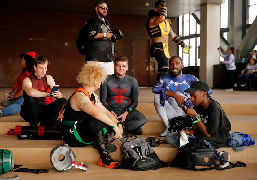 People dressed in fictional characters take a break on the outdoor plaza.