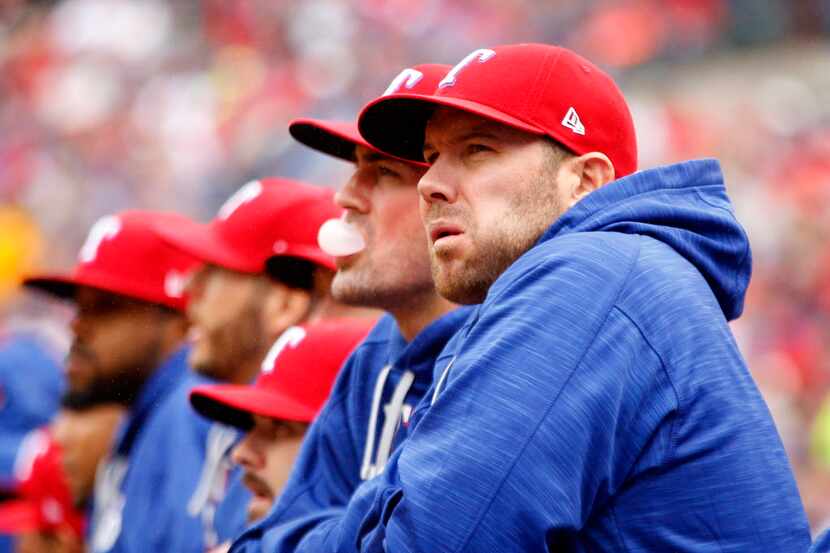 Texas Rangers starting pitchers Colby Lewis (right) and Cole Hamels watch the game from the...