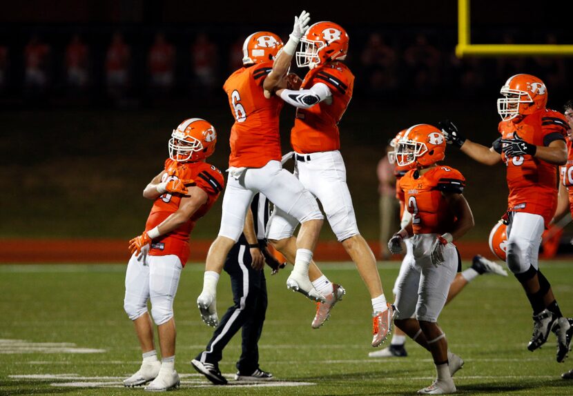 Rockwall's Zach Henry (6) and Jacob Clark (12) celebrate with teammates at the end of their ...