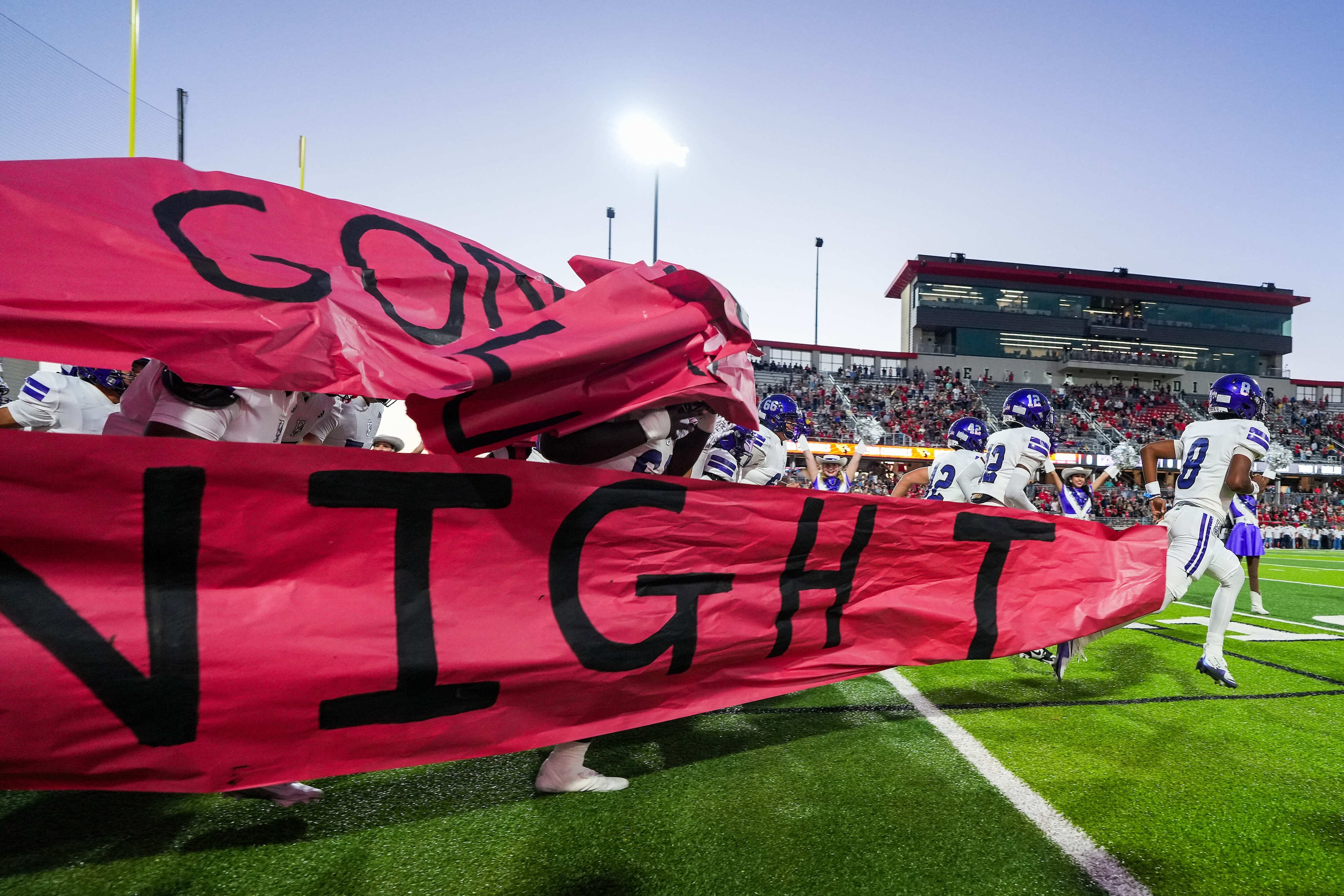 Anna quarterback Ziondre Williams (8) breaks through the banner as his team takes the field...