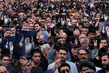 People held up posters of Iranian President Ebrahim Raisi during a mourning ceremony in...