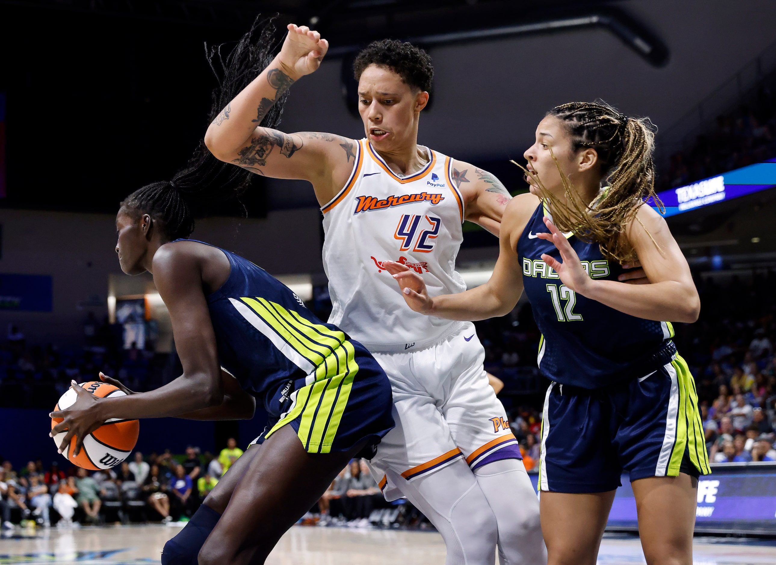 Dallas Wings center Awak Kuier (28, left) comes down with a rebound against Phoenix Mercury...