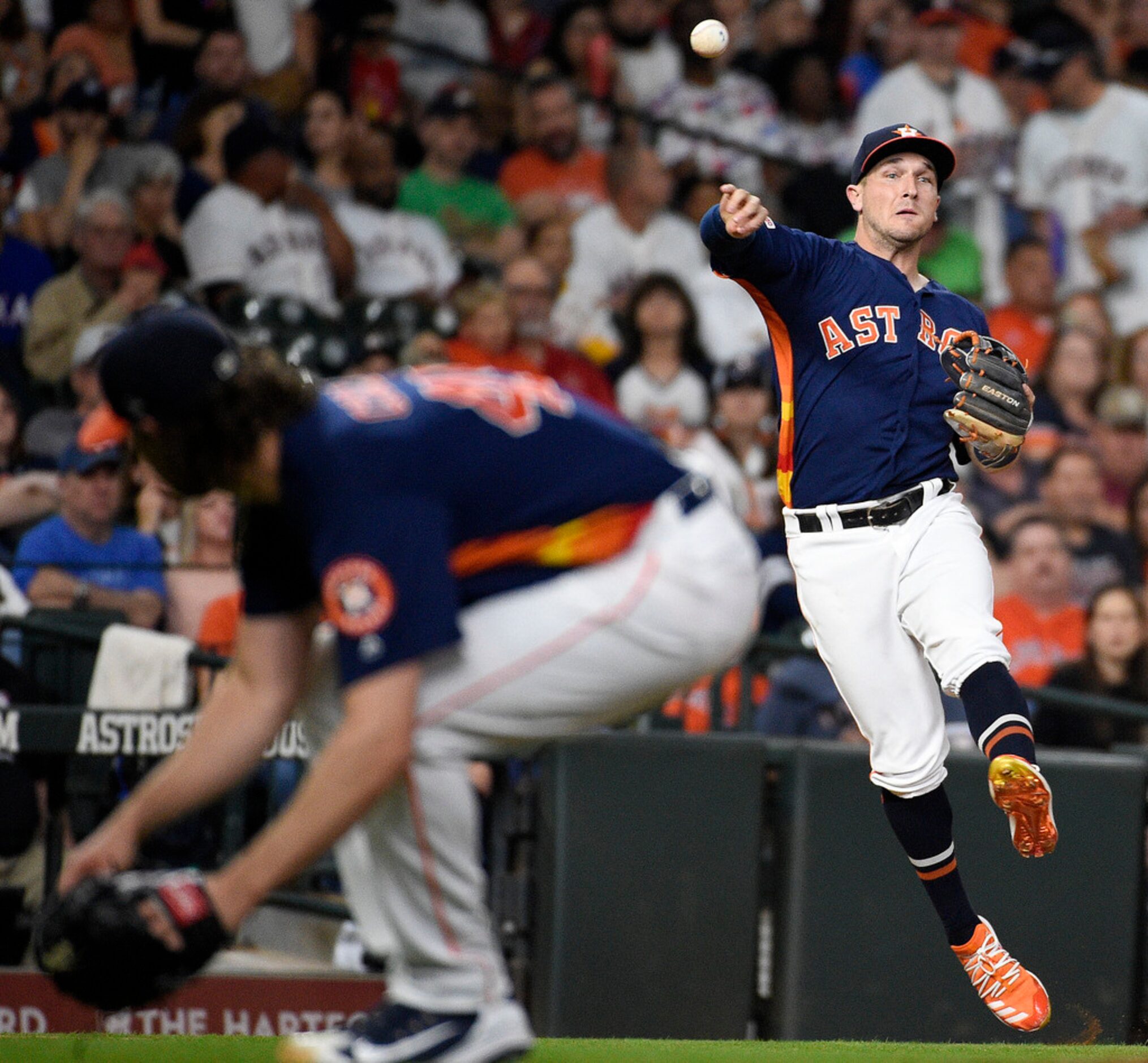 Houston Astros third baseman Alex Bregman, right, throws out Texas Rangers' Elvis Andrus as...