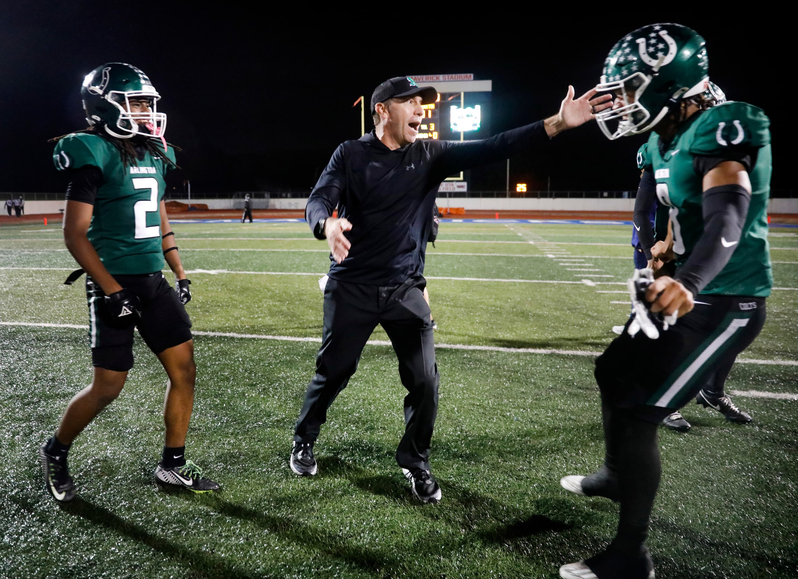 Arlington High head coach Scott Peach celebrates their 49-31 win over Arlington Martin with...