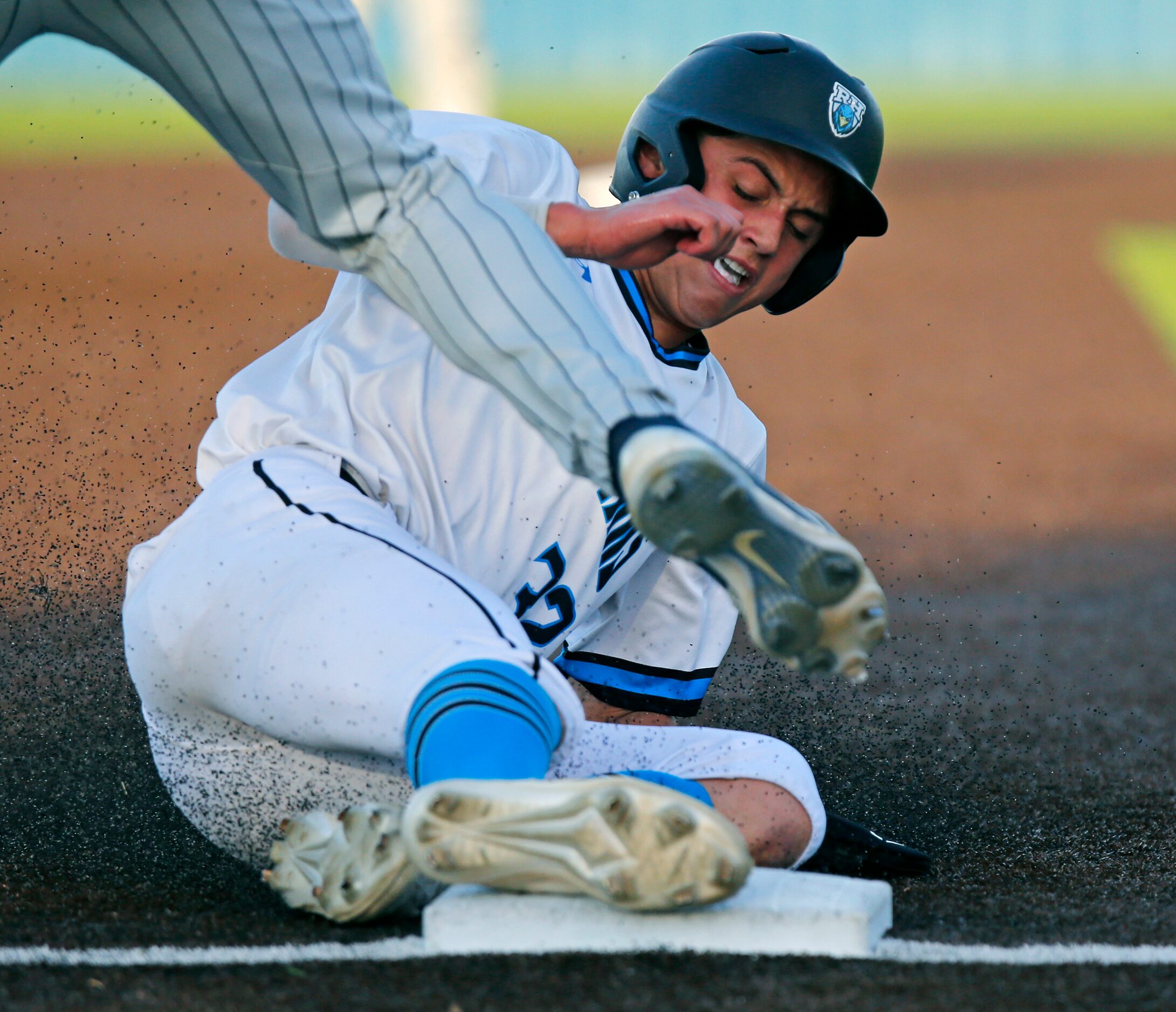 Rock Hill High School center fielder Brenner Cox (32) slides safely into third base as Lone...