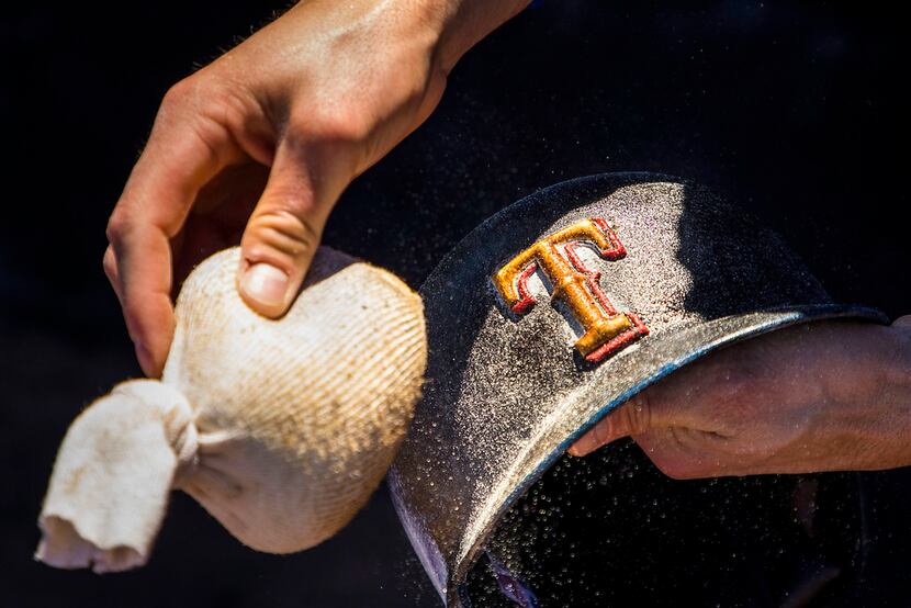 12:50 PM -- Robinson puts pine tar and rosin on his helmet before a spring training baseball...