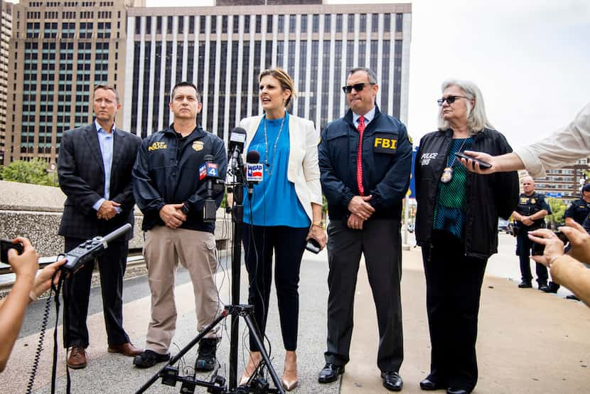 Erin Nealy Cox, center, U.S. Attorney for the Northern District of Texas, addresses the...