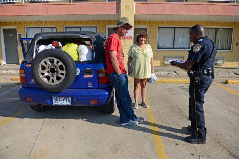 
Garland Neighborhood Police Officer Wendy Sheriff talks to Ronnie and Melanie Burk outside...