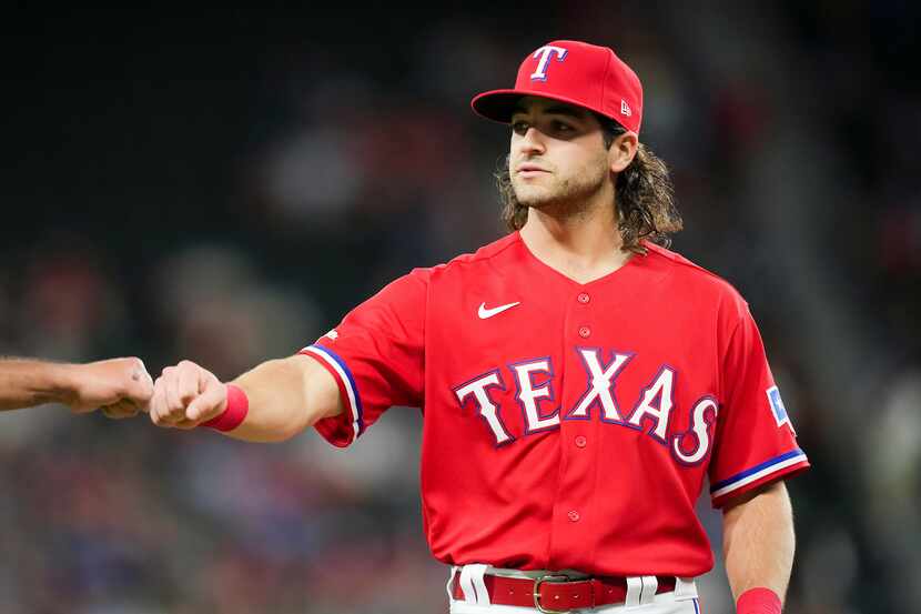 Texas Rangers third baseman Josh Smith first bumps an umpire as he takes the field for the...