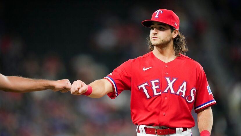 Texas Rangers third baseman Josh Smith first bumps an umpire as he takes the field for the...