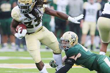 Baylor running back JaMycal Hasty, left, is pulled down by safety Connor Stanton, during...