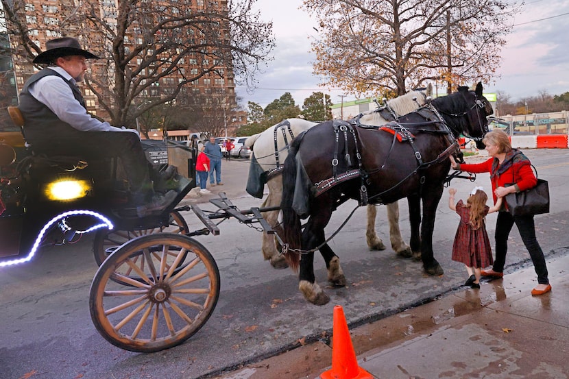 Elizabeth Irwin of Dallas and her granddaughter Harper Irwin, 4, of McKinney touch a horse...