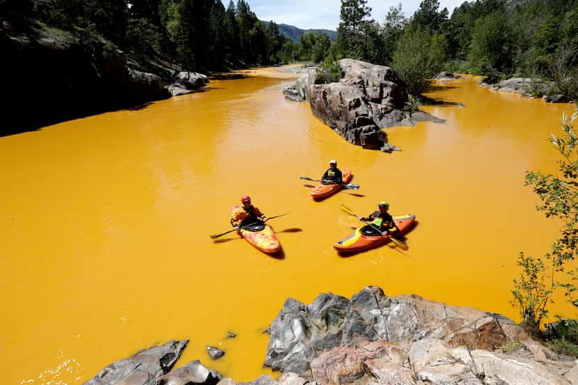 People kayak in the Animas River near Durango, Colo., Thursday, Aug. 6, 2015, in water...
