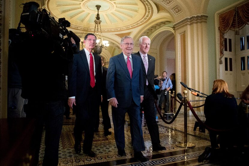 Senate Majority Leader Mitch McConnell of Ky., center, accompanied by Sen. John Barrasso,...