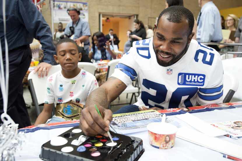 Dallas Cowboys running back Darren McFadden prepares to paint the face of Jaelon Williams,...