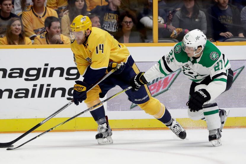 Dallas Stars left wing Antoine Roussel (21), of France, tries to take the puck from...