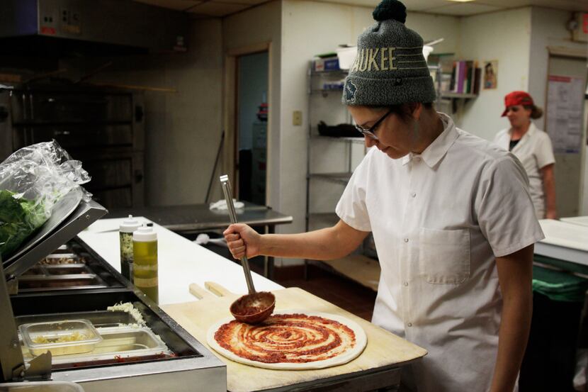 Andrea Ledesma spreads sauce on pizza dough at Classic Slice restaurant in Milwaukee....