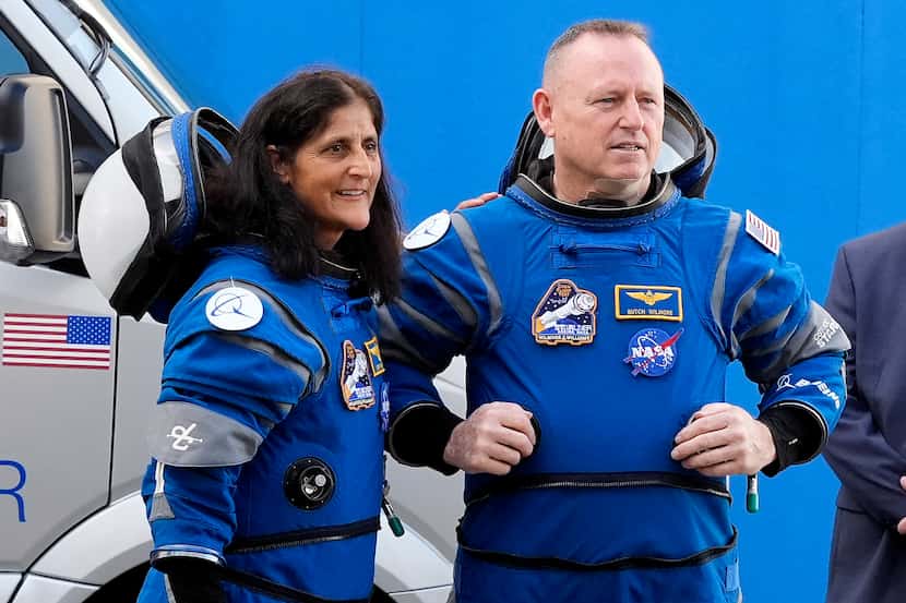 NASA astronauts Suni Williams, left, and Butch Wilmore talk to family members as they leave...