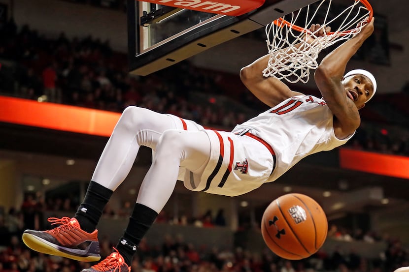 FILE - In this Feb. 27, 2019, file photo, Texas Tech's Tariq Owens hangs from the rim after...