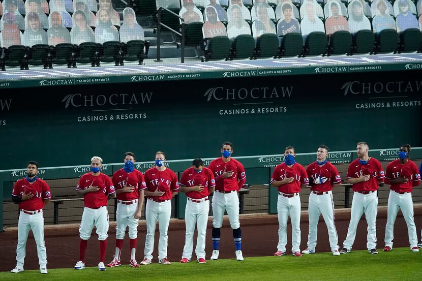 Texas Rangers players stand for the national anthem before a game against the Los Angeles...