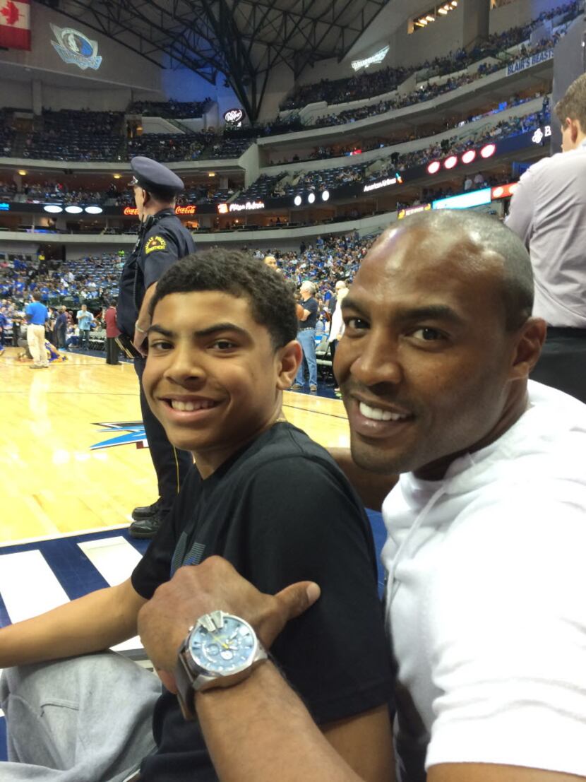 Former Cowboys player Darren Woodson and his son, Jaden, at a Mavericks game.