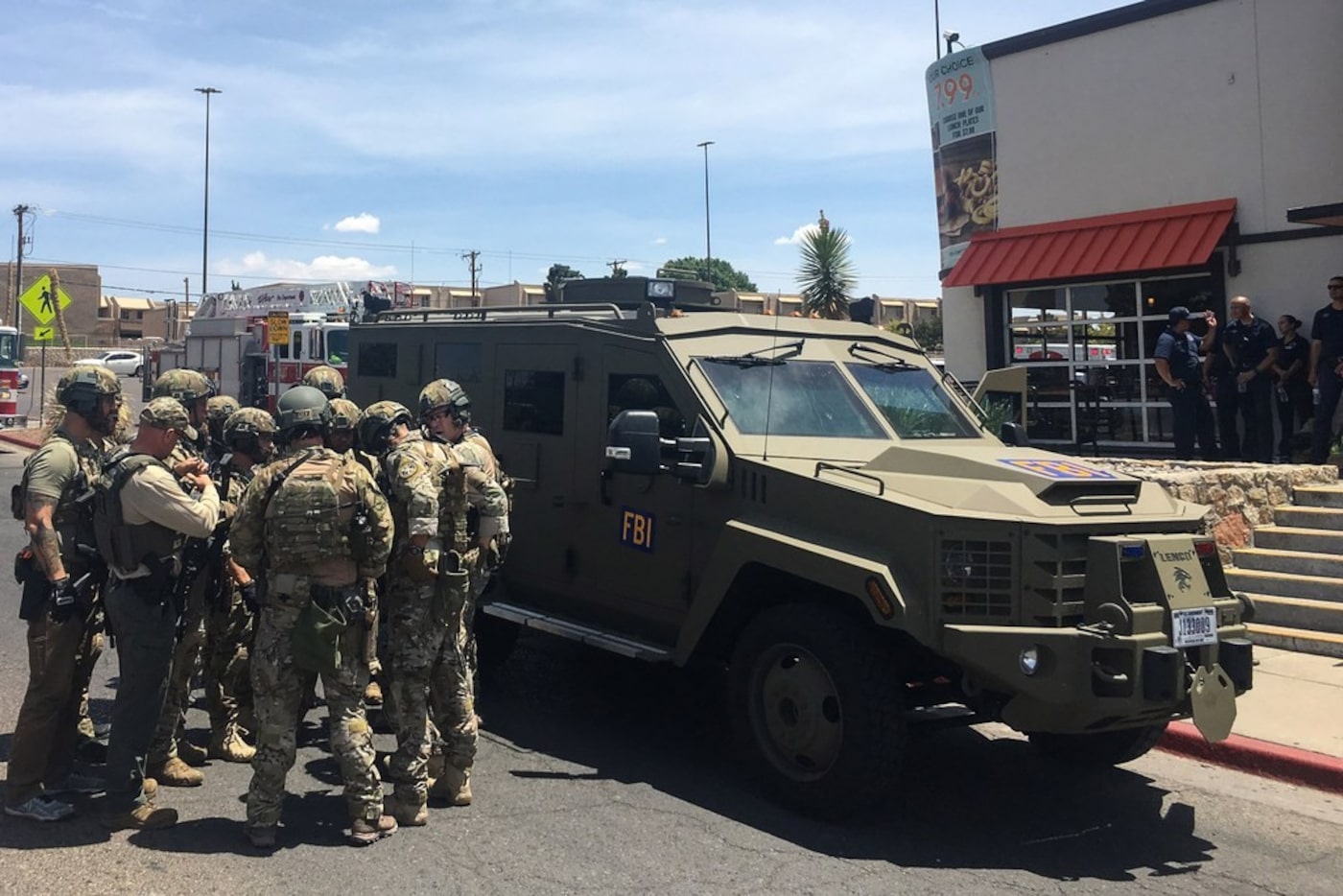 Armed Policemen gather next to an FBI armoured vehicle next to the Cielo Vista Mall as an...