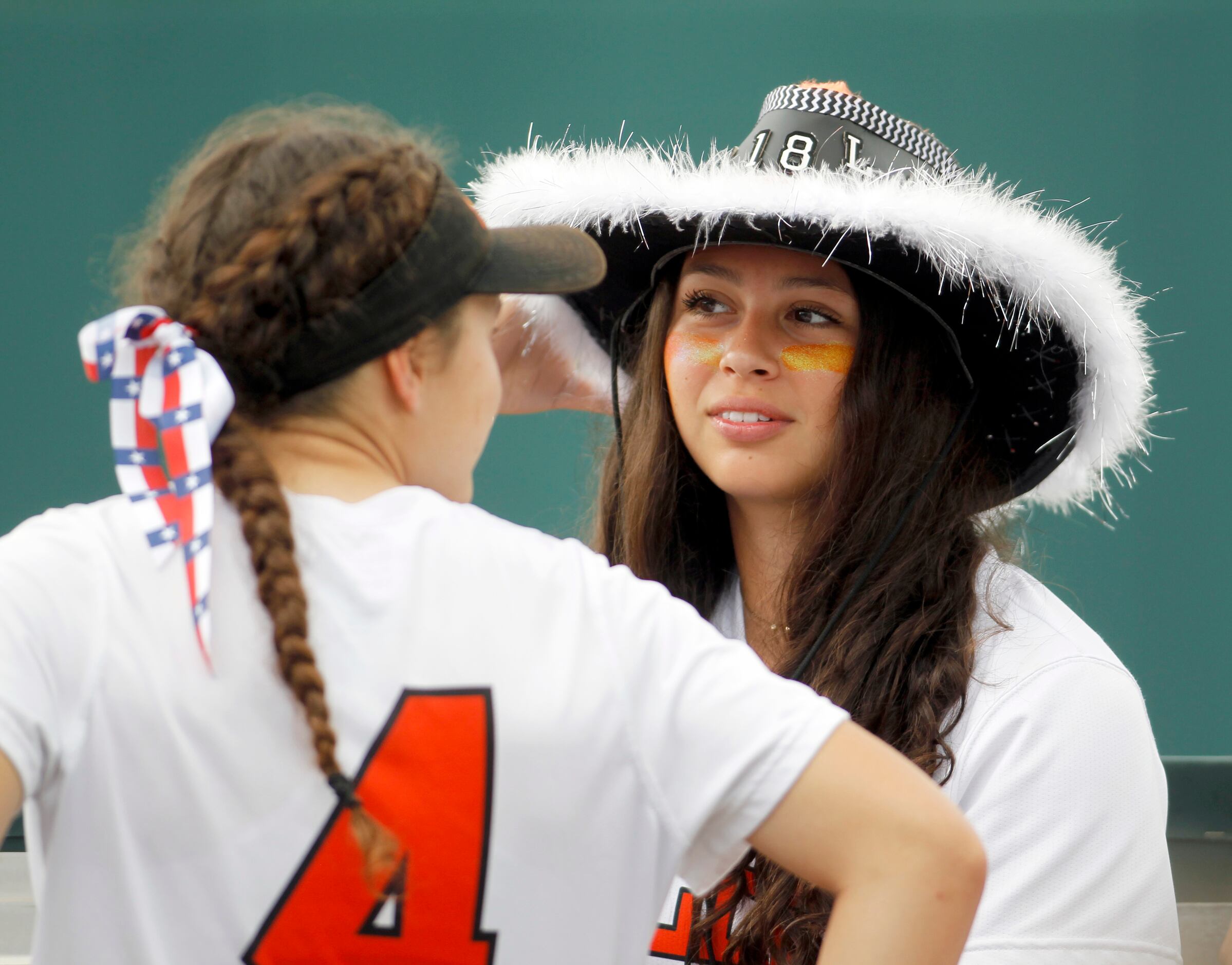 Aledo team manager Ana Flores (5), right, spends a light moment with Lady Cats infielder...