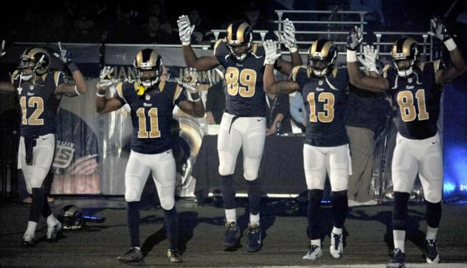 Cinco jugadores de los Rams de St. Louis salieron al campo con las manos en alto, en...
