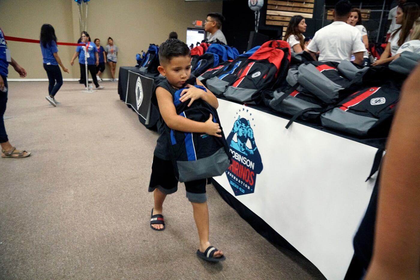 Nathaniel Ojeda (6) struggles to carry the new backpack he got at the Back to School Block...