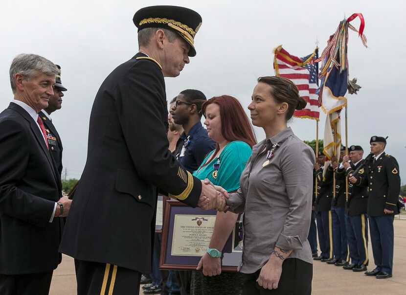  Lt. Gen. Sean B. MacFarland, center, shakes the hand of Defense of Freedom Medal recipient,...