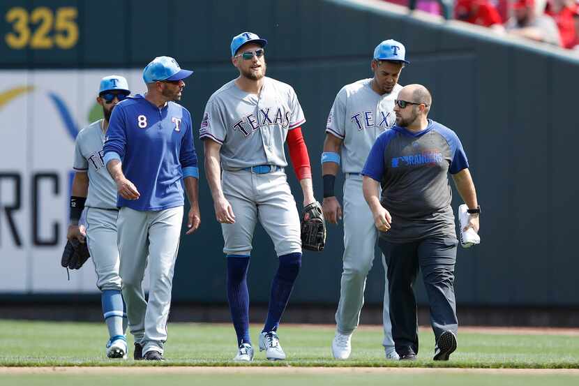 Hunter Pence (24) of the Texas Rangers walks off the field with manager Chris Woodward after...