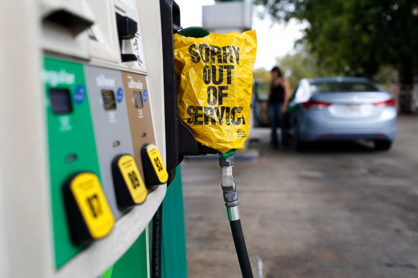 A "Sorry out of Service" sign is placed on one of the gas pumps at a gas station in Athens,...