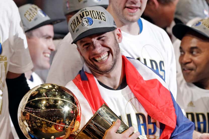 Dallas Mavericks' Jose Juan Barea holds up the championship trophy after Game 6 of the NBA...