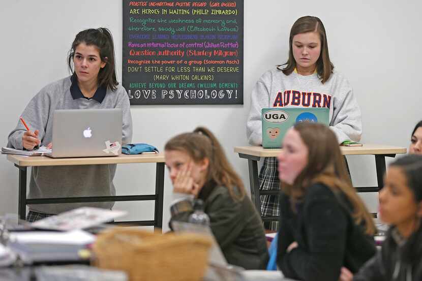 Twelve-graders Shelby Stansbury, 17, left, and Sarah Kate Farmer, 18, use standing desks...