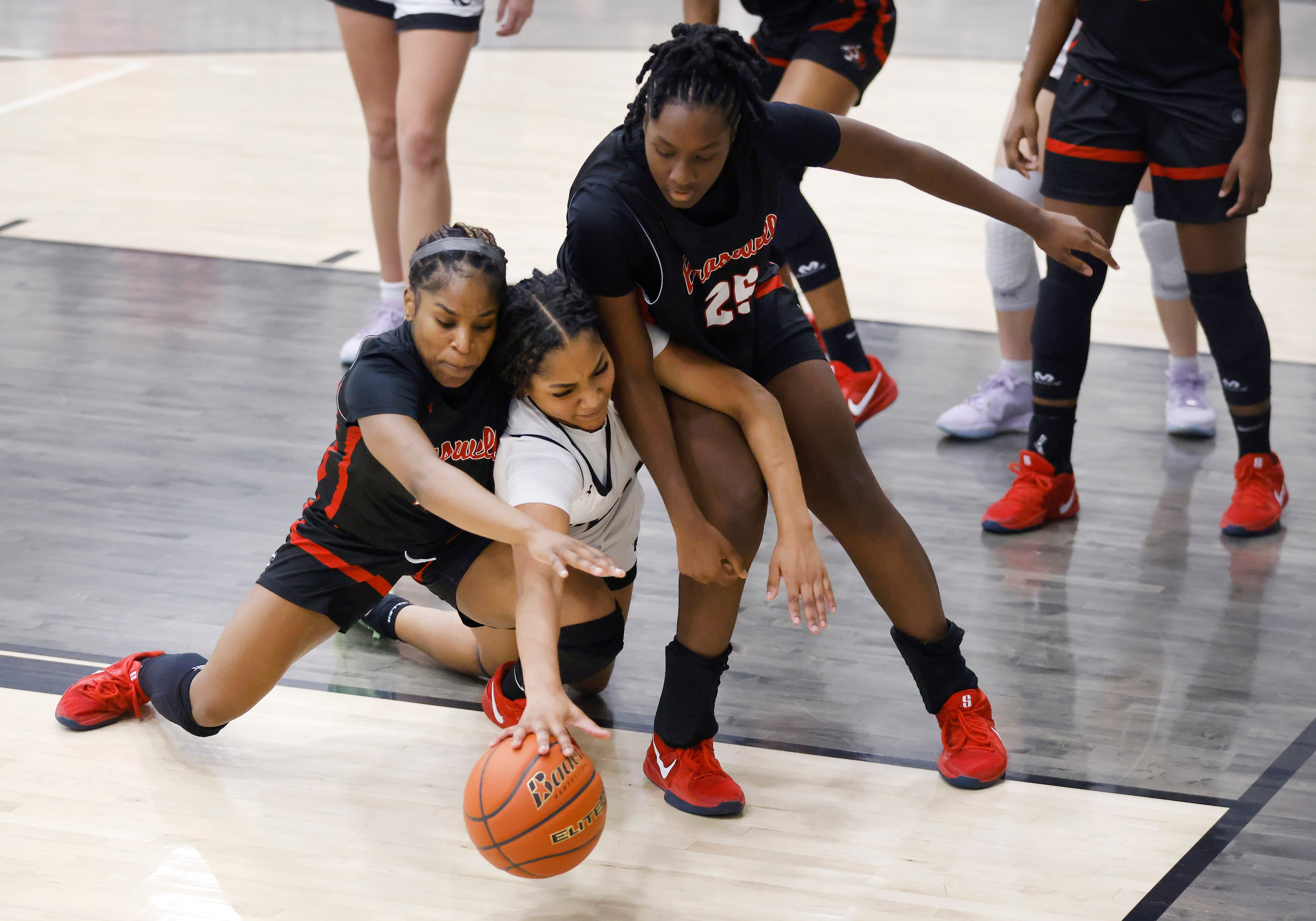 Denton Guyer guard Destanie Green (center)  is squeezed out by Denton Braswell’s Hannah...