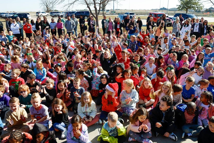 Dozens of students at Amy Parks-Heath Elementary cheer as custodian Lucino Perez is...