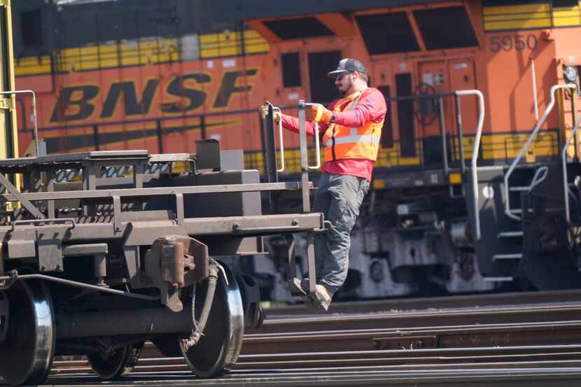 A worker rides a rail car at a BNSF rail crossing in Saginaw, Texas, Wednesday, Sept. 14,...