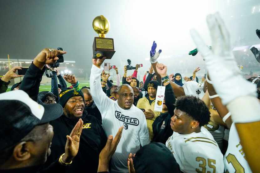 South Oak Cliff head coach Jason Todd raises the game trophy following a victory over Argyle...