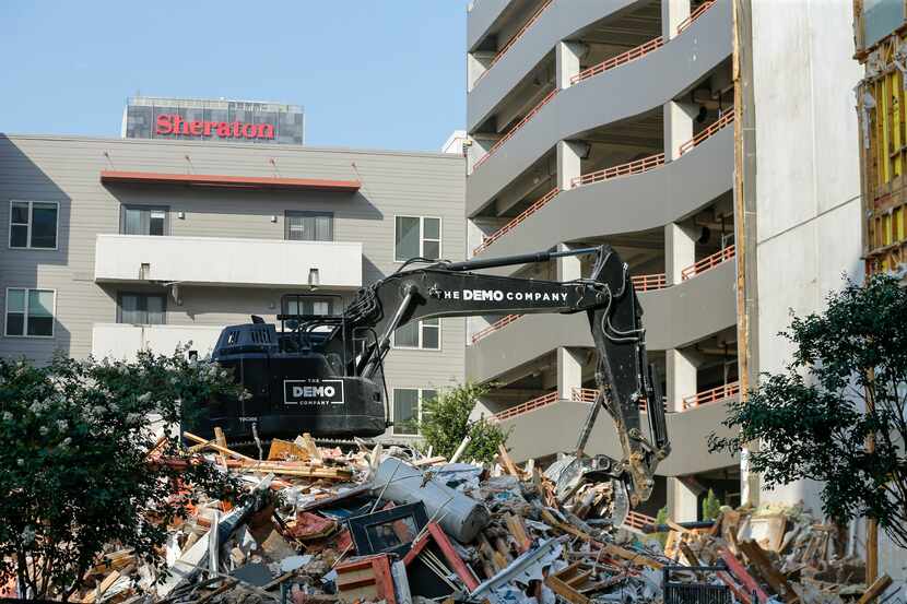 An excavator cleared debris at the Elan City Lights apartments Wednesday in Dallas. A...