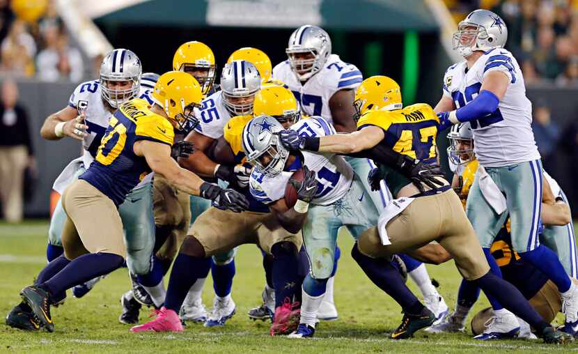 Dallas Cowboys running back Ezekiel Elliott (21) fights off Green Bay Packers inside...