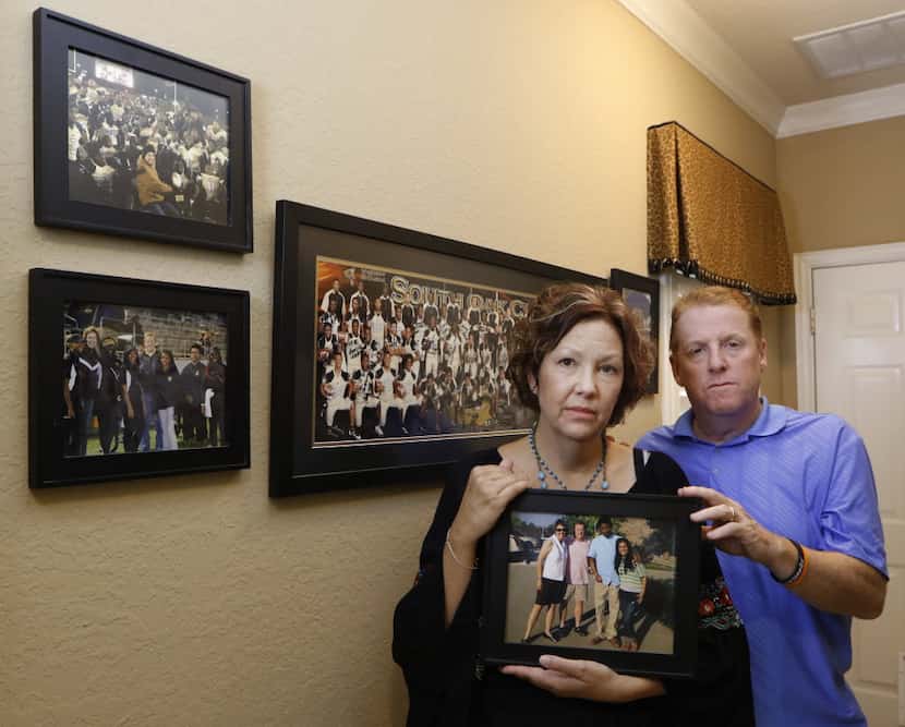 Lisa and Dave Stephenson hold a photograph of them with Thomas Johnson, whom they took into...