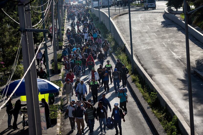 A group of Central American migrants resume their journey north after leaving the temporary...