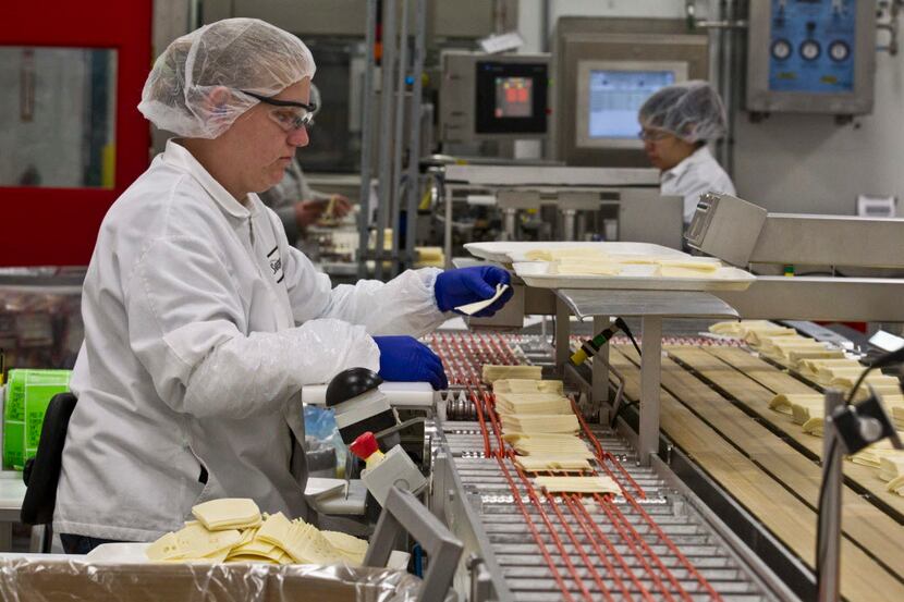 ORG XMIT: WIMG504 Samantha Hansen inspects slices of cheese at the Sargento Cheese Company...