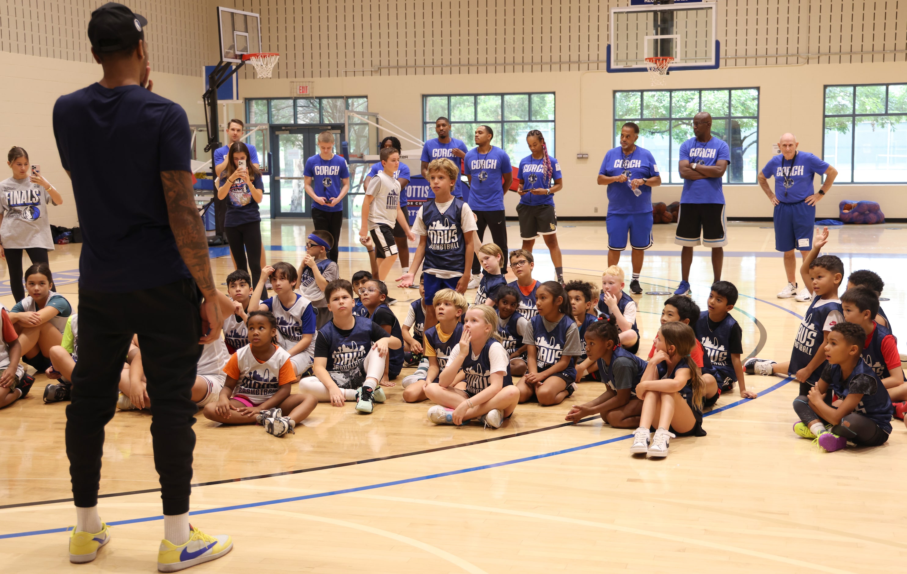 Dallas Mavericks forward and center PJ Washington, left, answers a question posed by a Hoop...