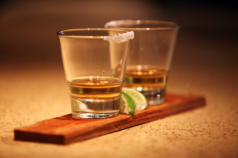 Two shot glasses of cedar wood-infused tequila at Smoke Restaurant in Dallas, which also...