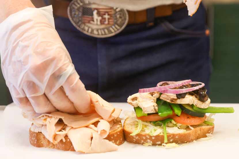 David Jordan, owner of Patriot Sandwich Co., makes sandwiches for customers Saturday, March,...