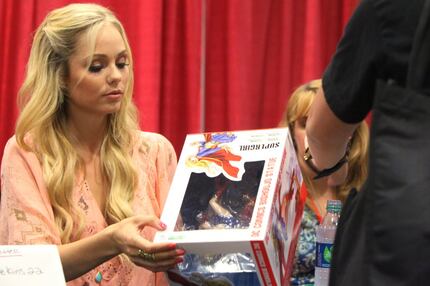 Laura Vandervoort signs a  Supergirl toy for a fan at Dallas Comic Con at the Irving...